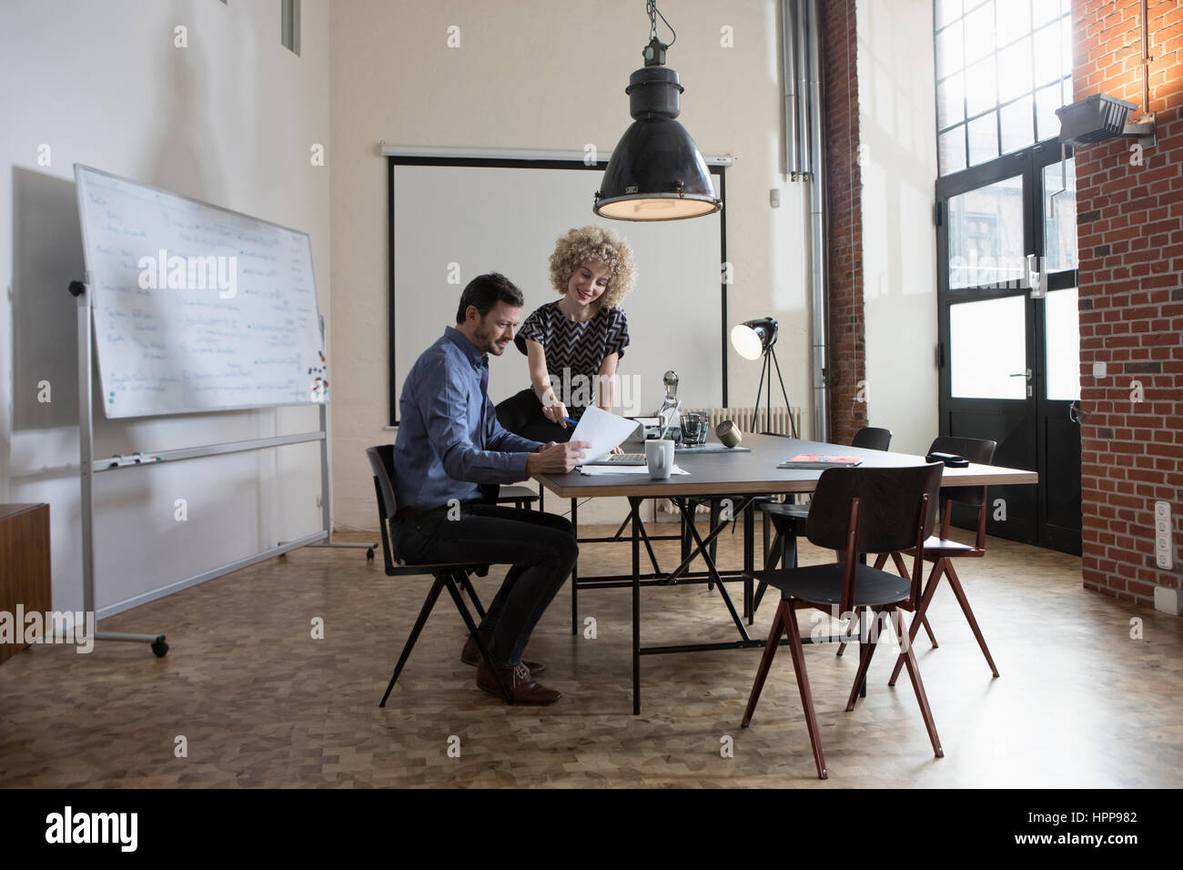 Man and woman discussing document in boardroom Stock Photo - Alamy