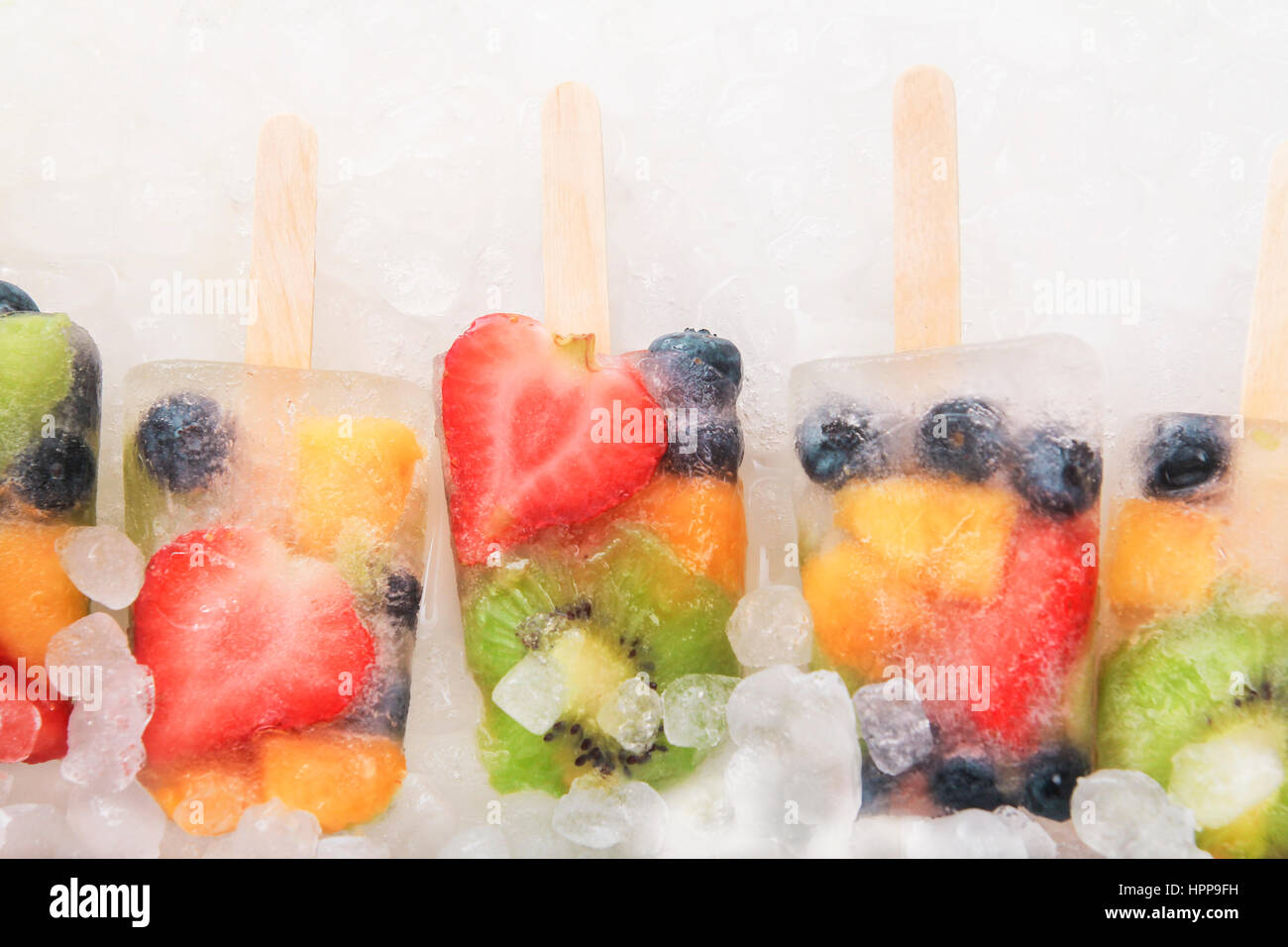 Row fruit ice lollies with fresh fruits on white ground Stock Photo Alamy