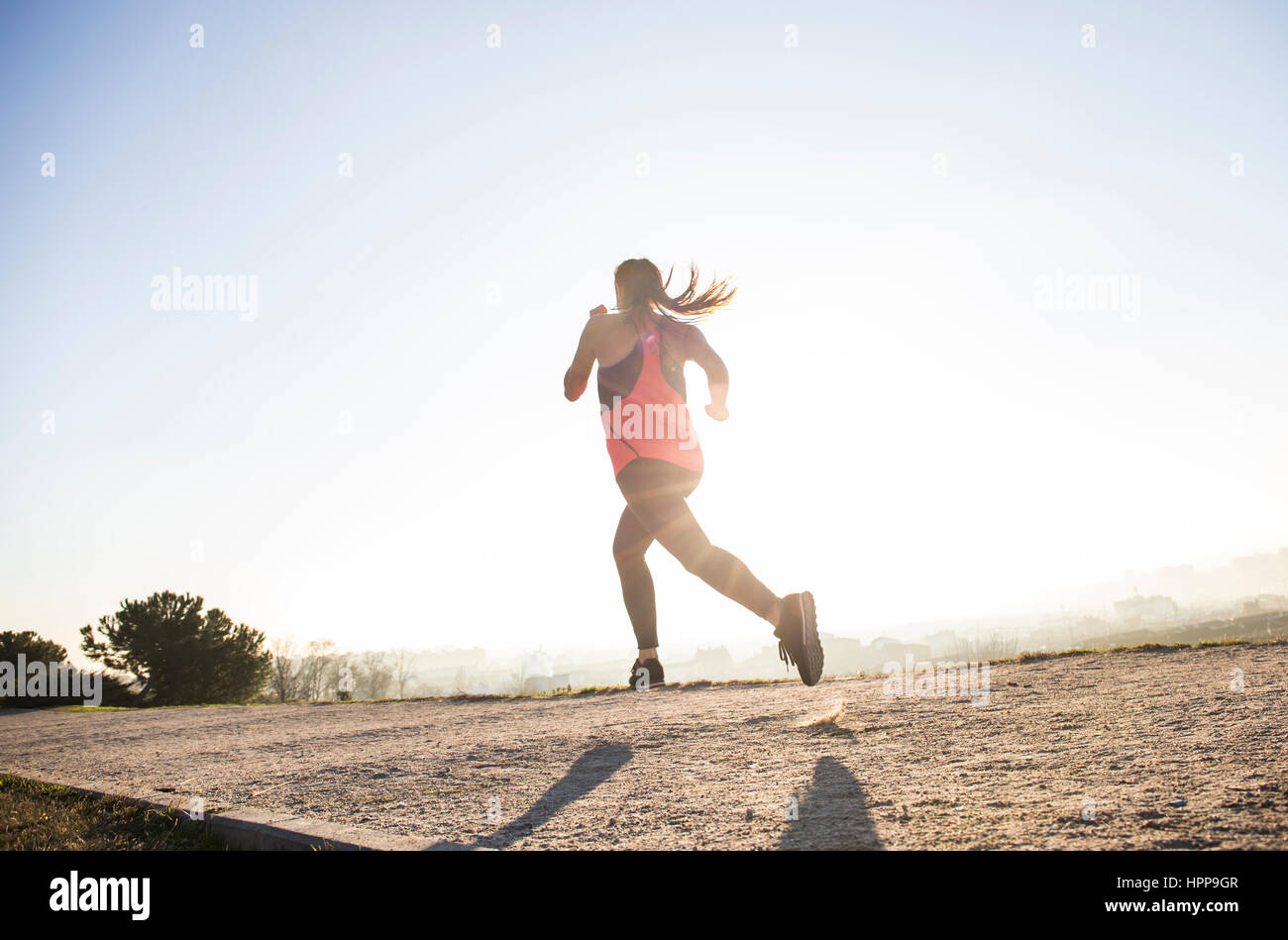 Young woman running in sunlight Stock Photo