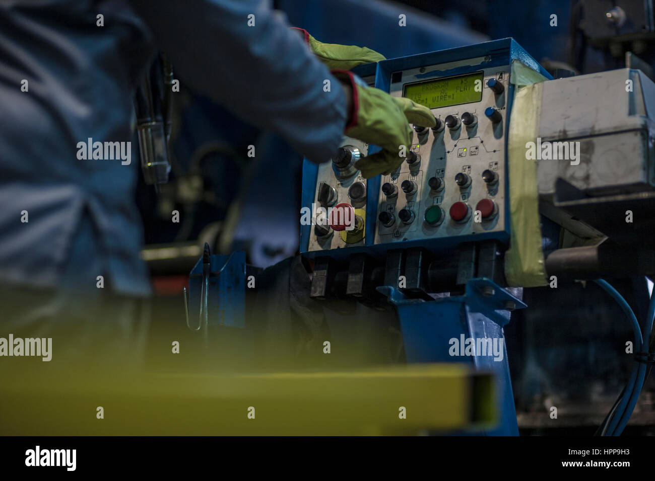Worker operating machinery at control panel in factory Stock Photo - Alamy