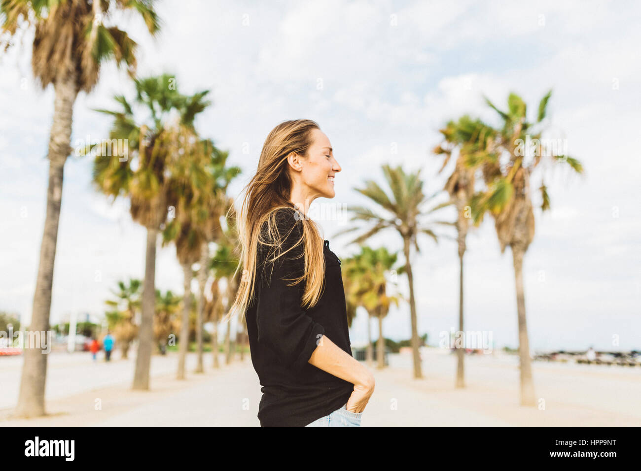 Smiling young woman on waterfront promenade Stock Photo - Alamy