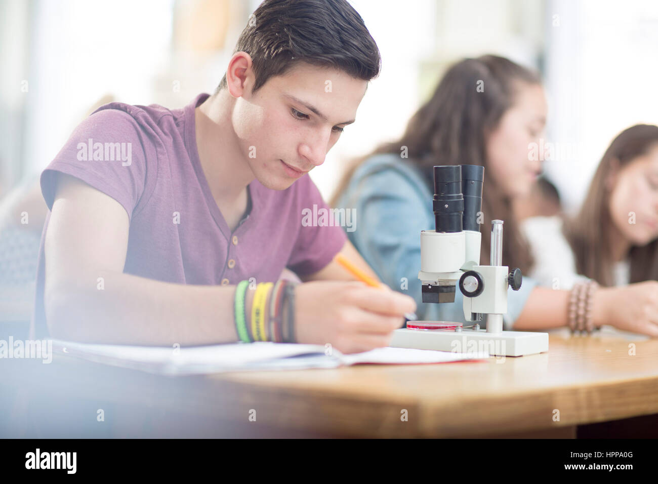 Science student working in class with microscope Stock Photo - Alamy