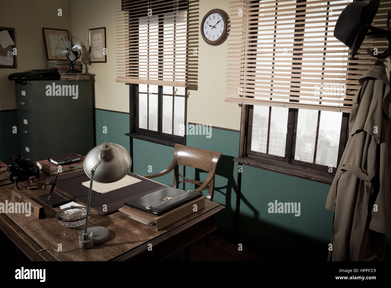 1950s style office with director's desk, vintage phone, file cabinet and other retro items, urban panorama outside. Stock Photo