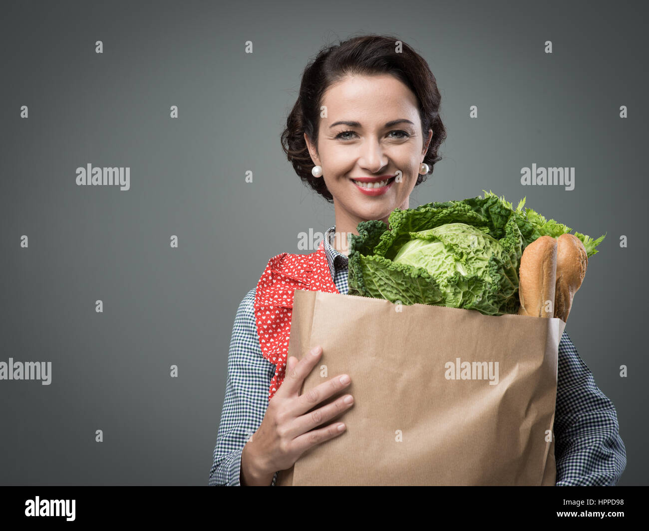 Smiling vintage woman in apron holding a shopping grocery bag Stock ...