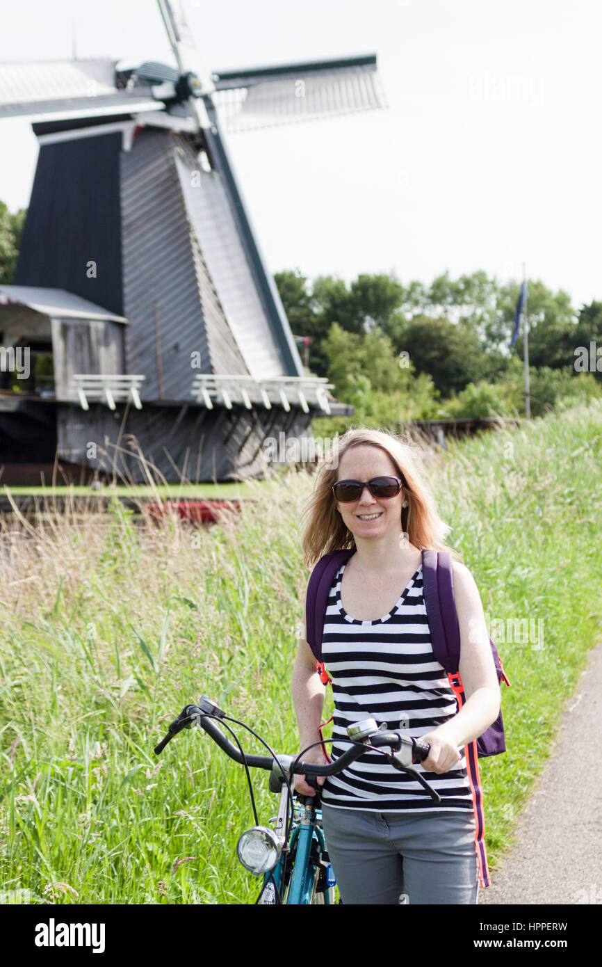 Woman with bicycle on path by Zuider Buiten Spaarne river, outskirts of Haarlem Stock Photo