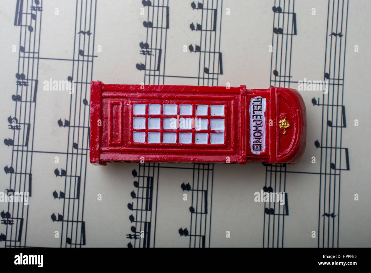 Telephone booth is placed on paper with musical notes Stock Photo