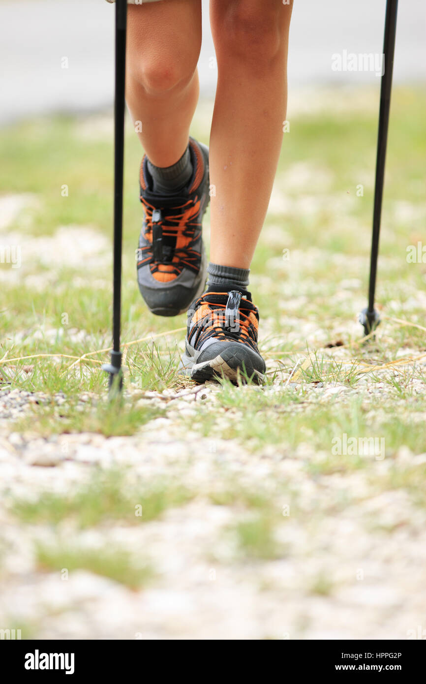 Woman hiking and nordic walking in forest. Sport shoe close up Stock Photo