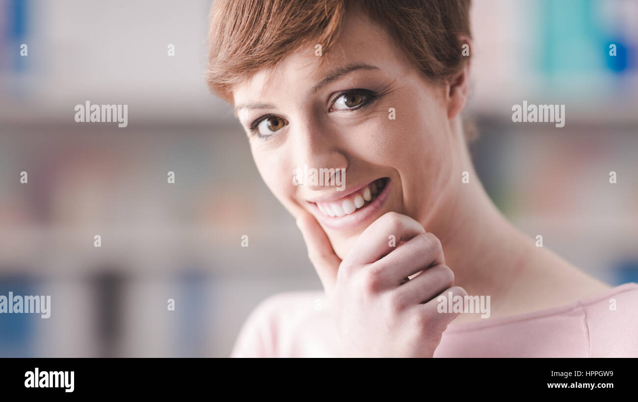 Smiling young woman posing with hand on chin Stock Photo - Alamy