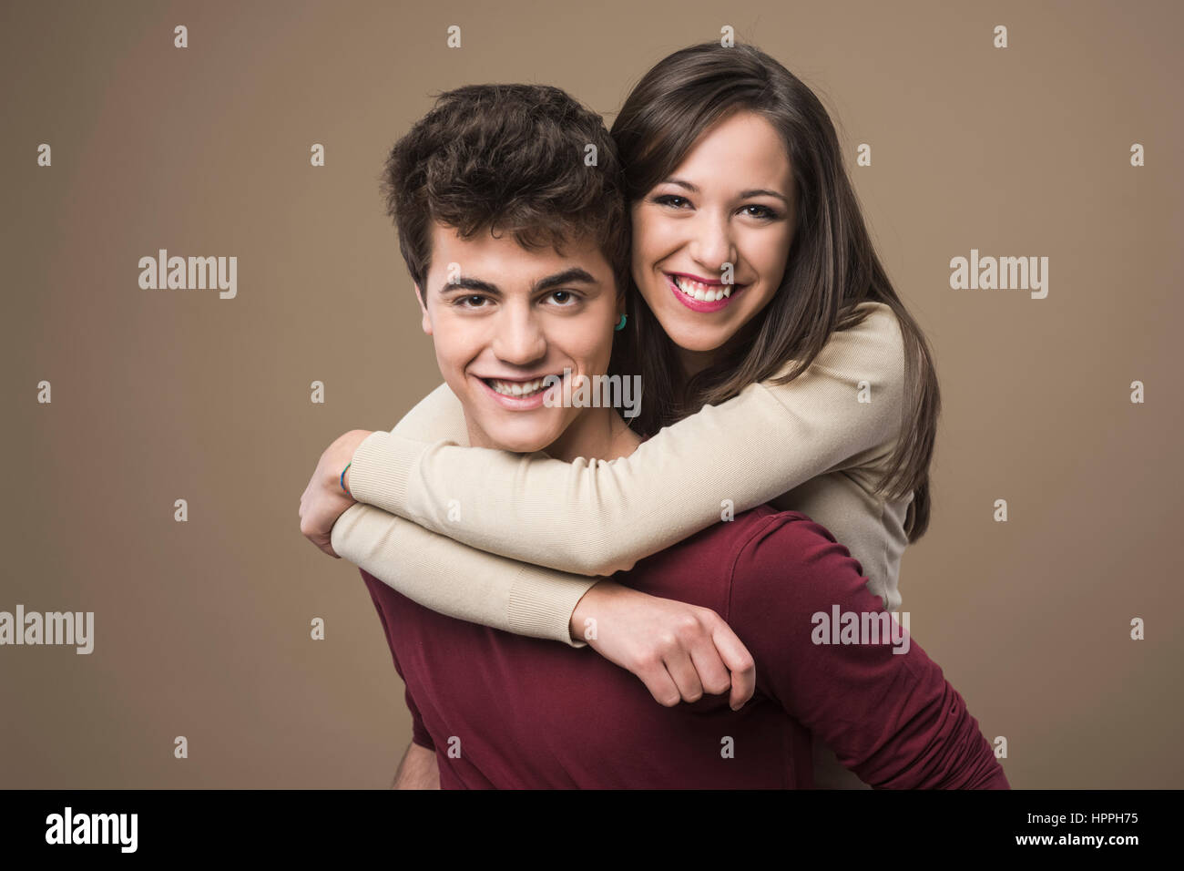 Happy young loving couple hugging and smiling at camera Stock Photo - Alamy