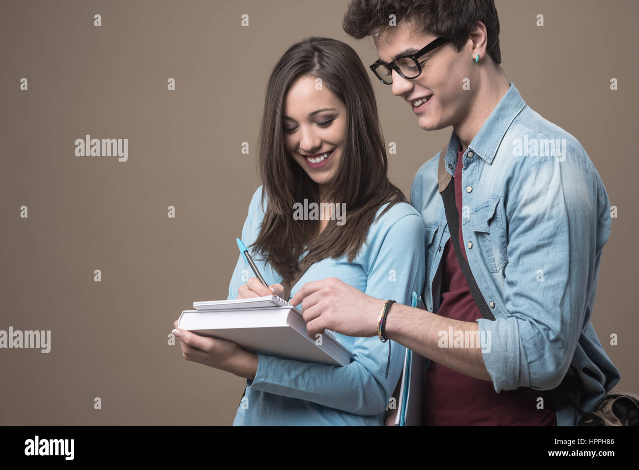 Happy teenager students holding textbooks and smiling Stock Photo - Alamy