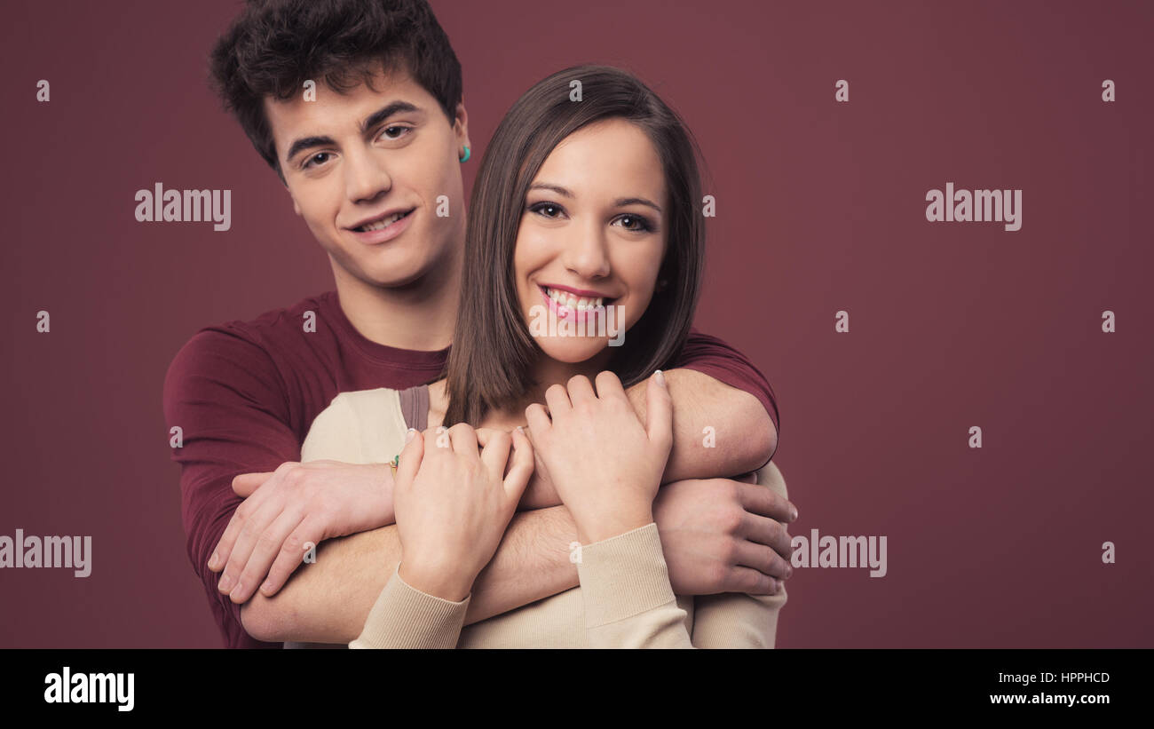 Happy young loving couple hugging and smiling at camera Stock Photo - Alamy