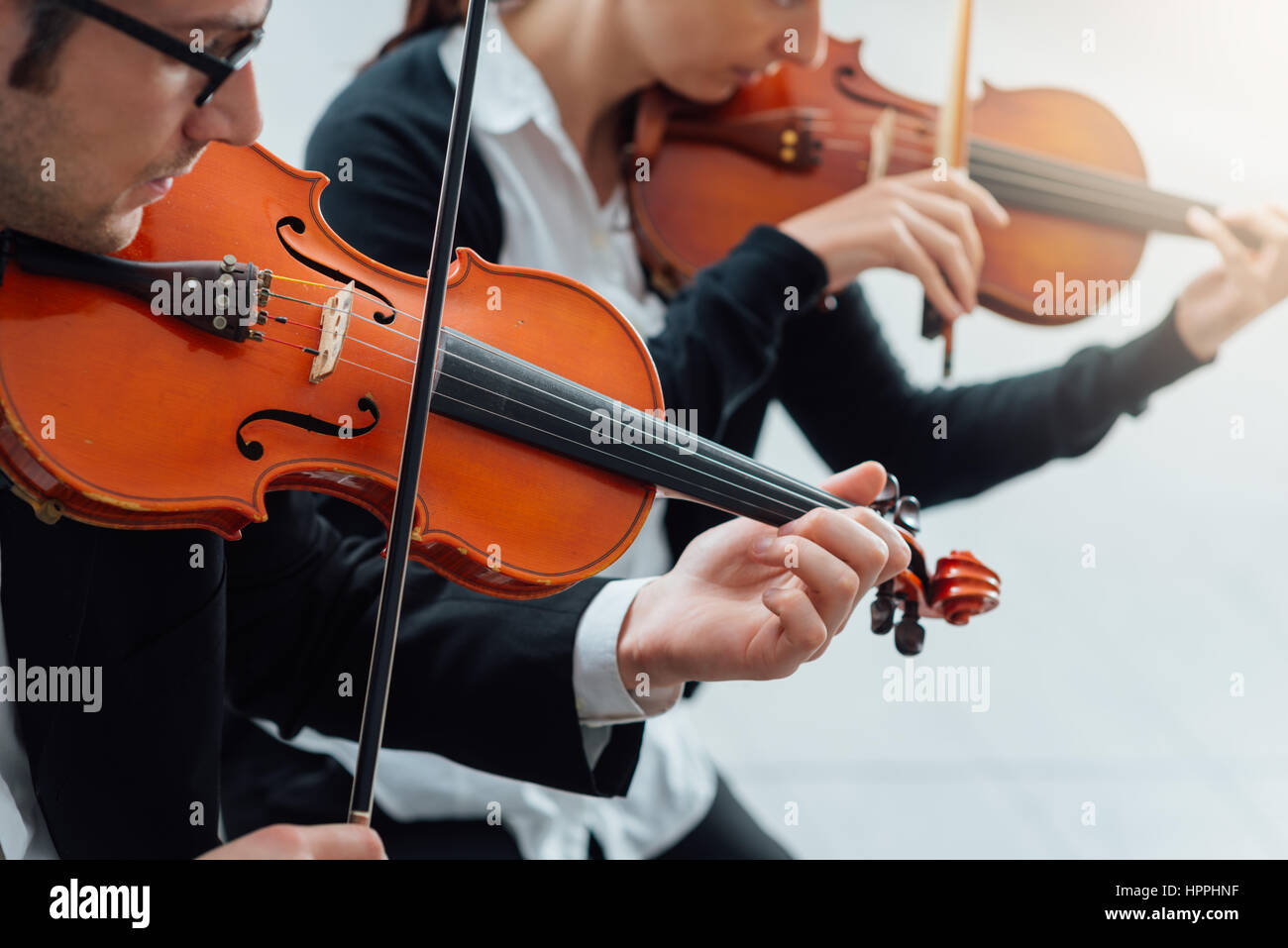 Two violinists performing together hands close up, classical music