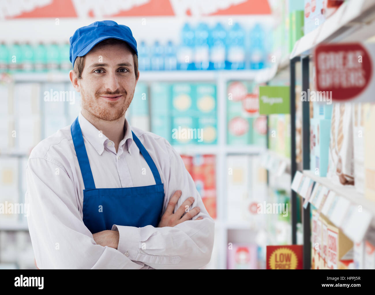 Confident smiling supermarket clerk posing at the shopping mall, retail