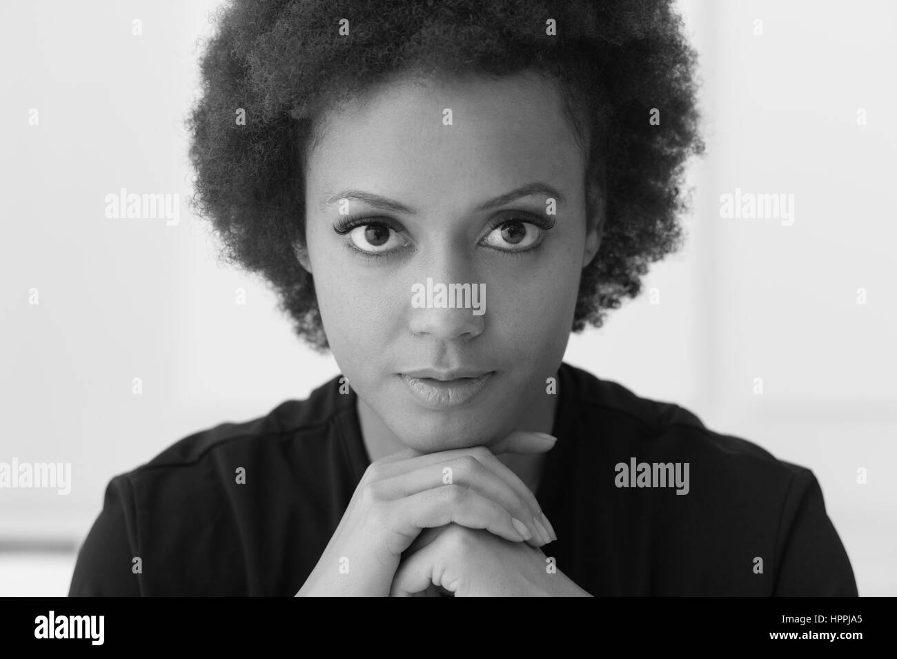 Confident young african american woman posing and looking at camera ...