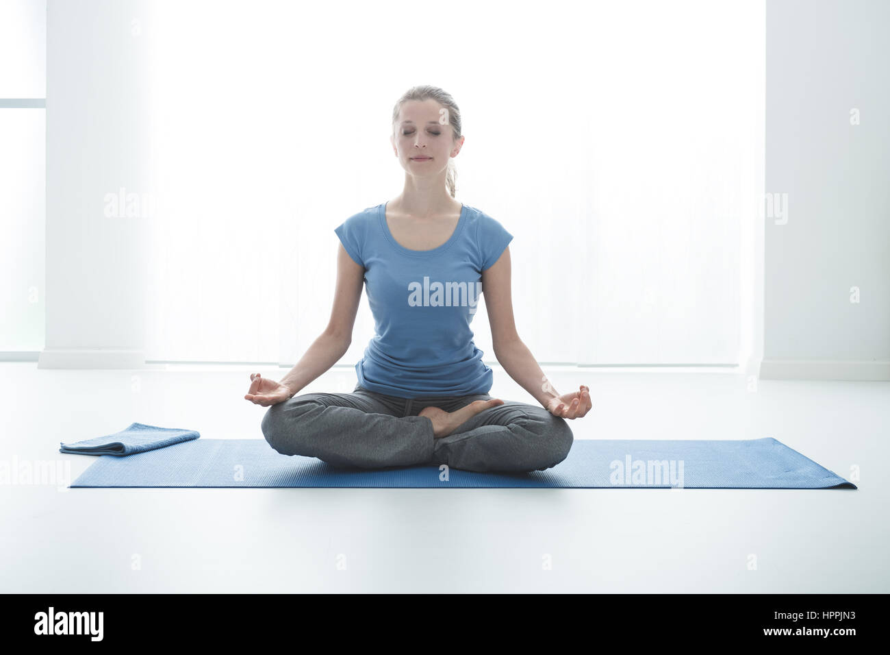 Woman sitting on the floor and doing the lotus position, yoga and ...