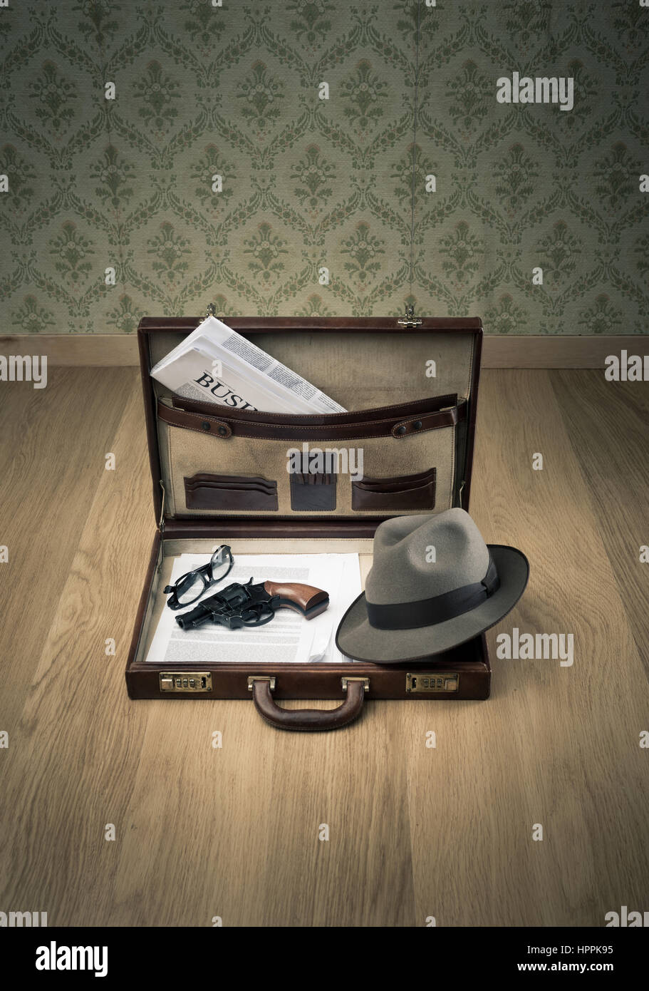 Open vintage leather briefcase with detective hat, revolver gun and