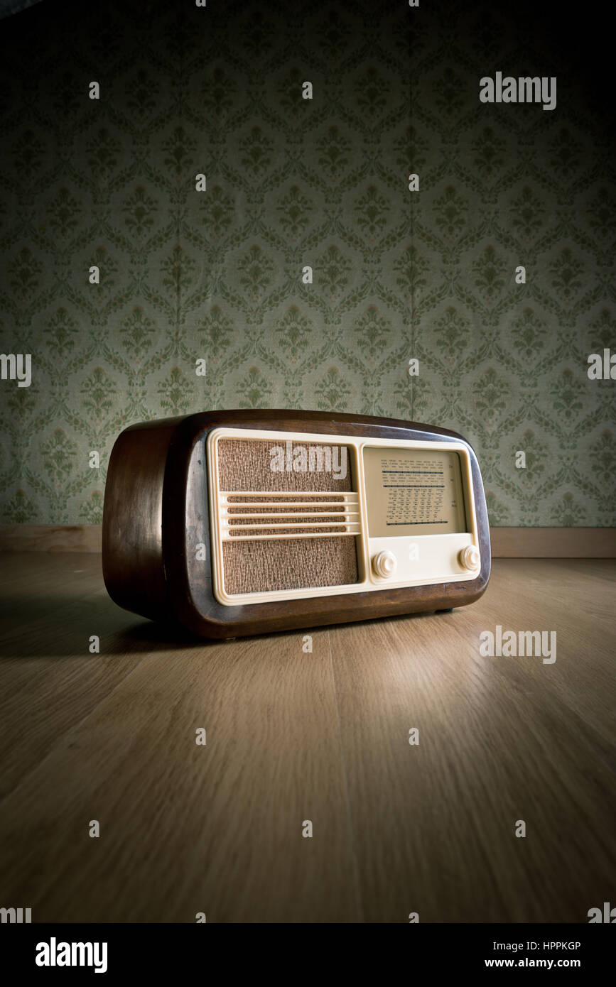 Old vintage radio on hardwood floor with retro wallpaper on background  Stock Photo - Alamy