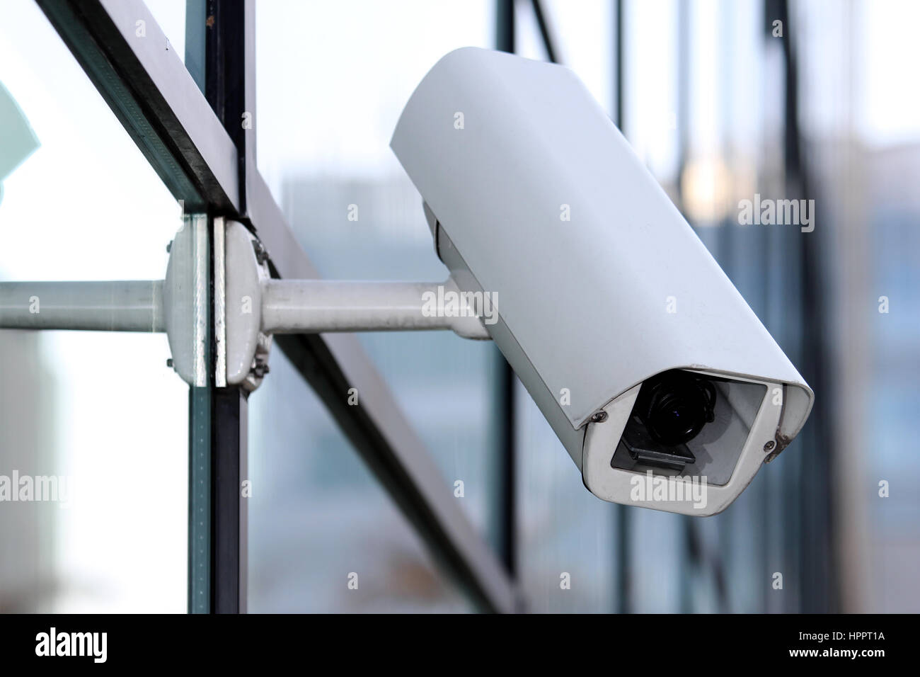 white security cctv camera on glass facade Stock Photo