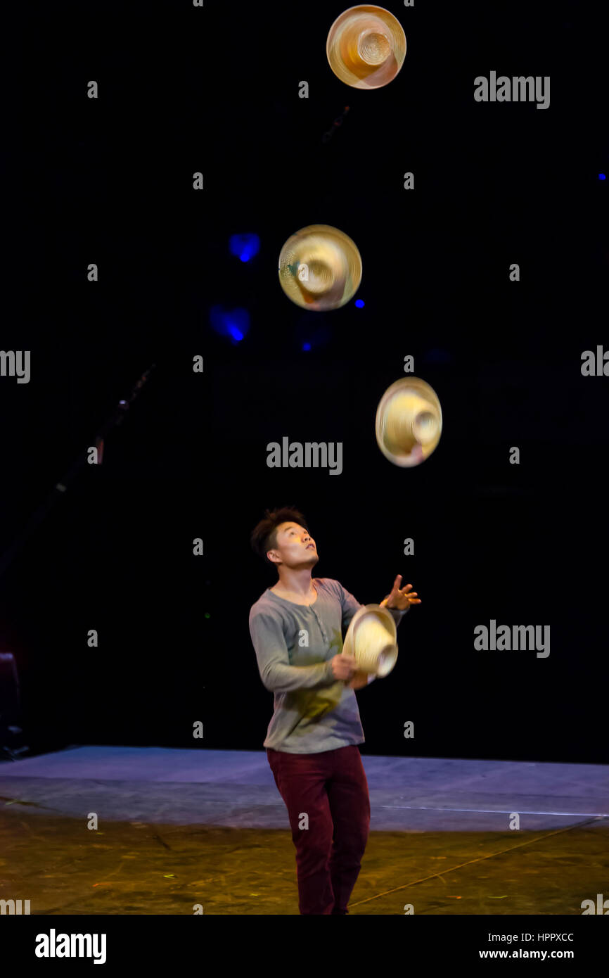 Asian man Juggling hats. A muse Circus. Compañía Les 7 doigts de la