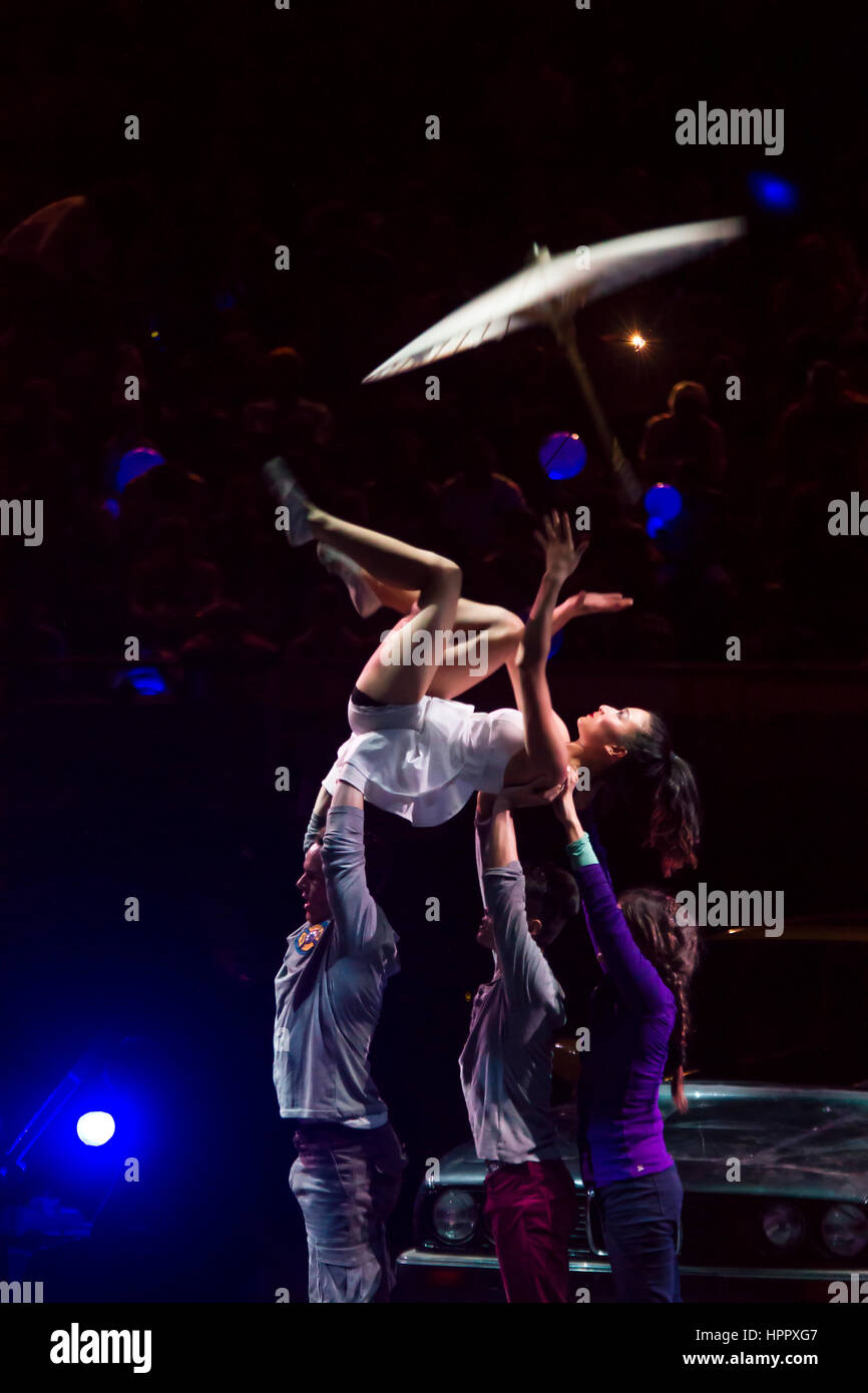 Asian woman Juggling umbrella carrying by people. A muse Circus