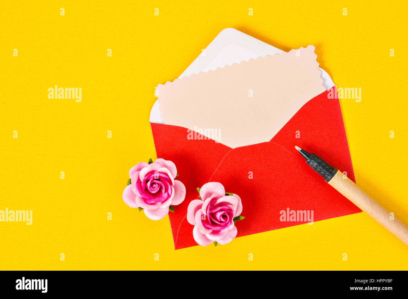 Blank pink paper card in red envelope letter and pen with pink roses on ...
