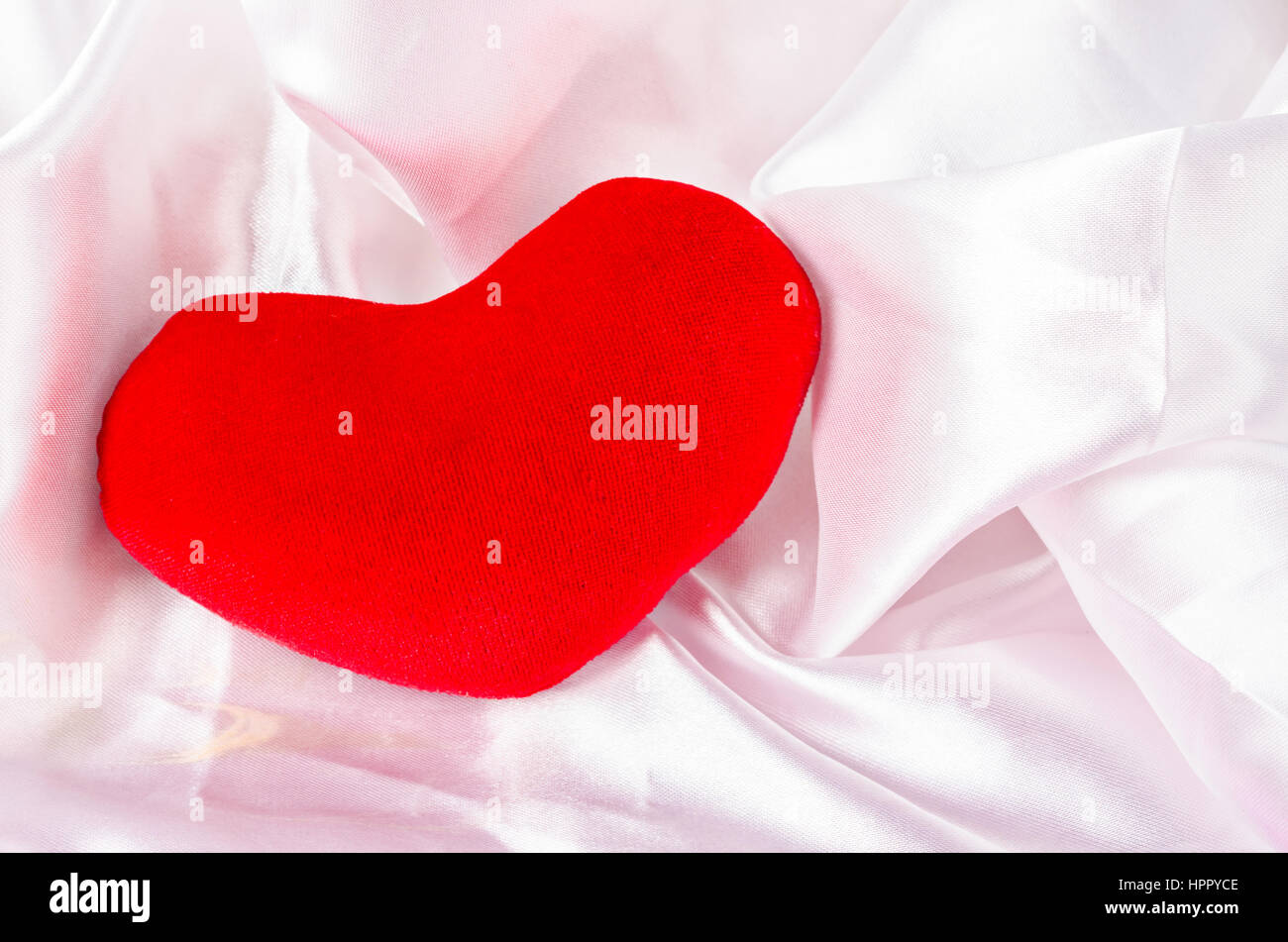 Red heart on elegant white fabric background Stock Photo - Alamy