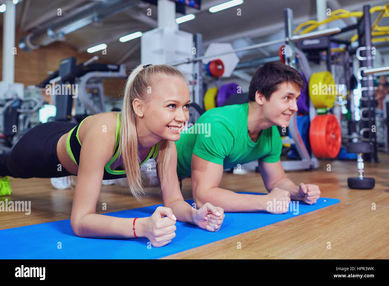Sport couple doing pushups bar on floor in the gym Stock Photo - Alamy