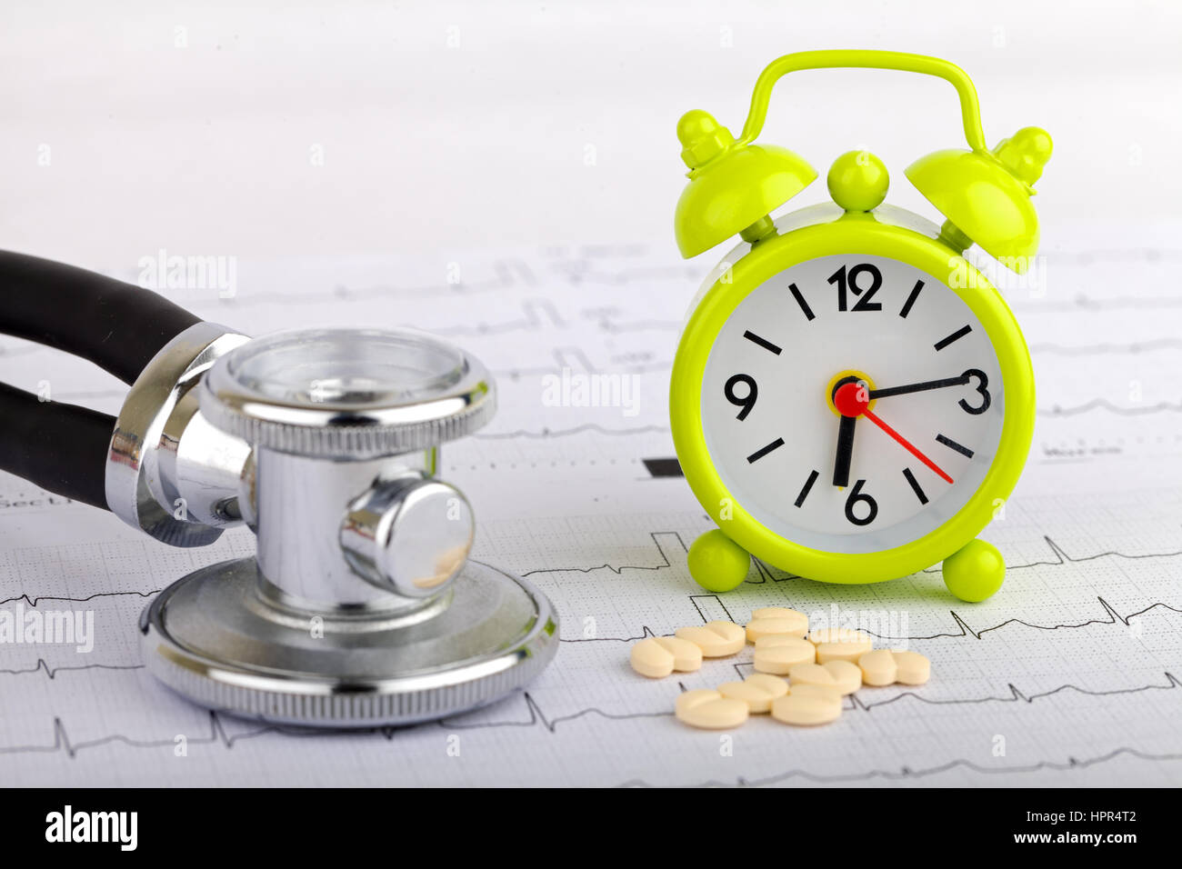 Electrocardiogram graph report with stethoscope and a clock on it Stock Photo