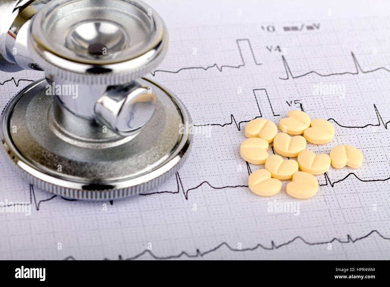 Electrocardiogram graph report with stethoscope and pills on it Stock Photo