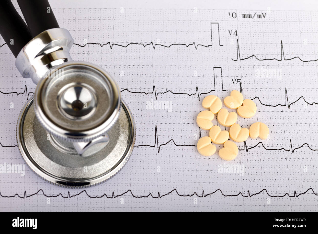 Electrocardiogram graph report with stethoscope and pills on it Stock Photo