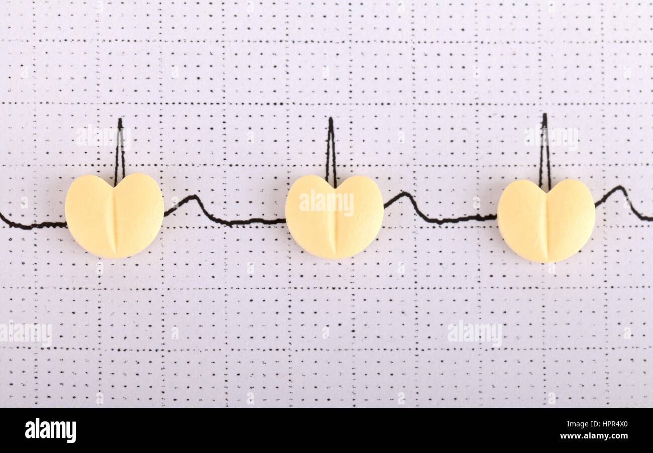 Electrocardiogram graph report with  pills on it Stock Photo