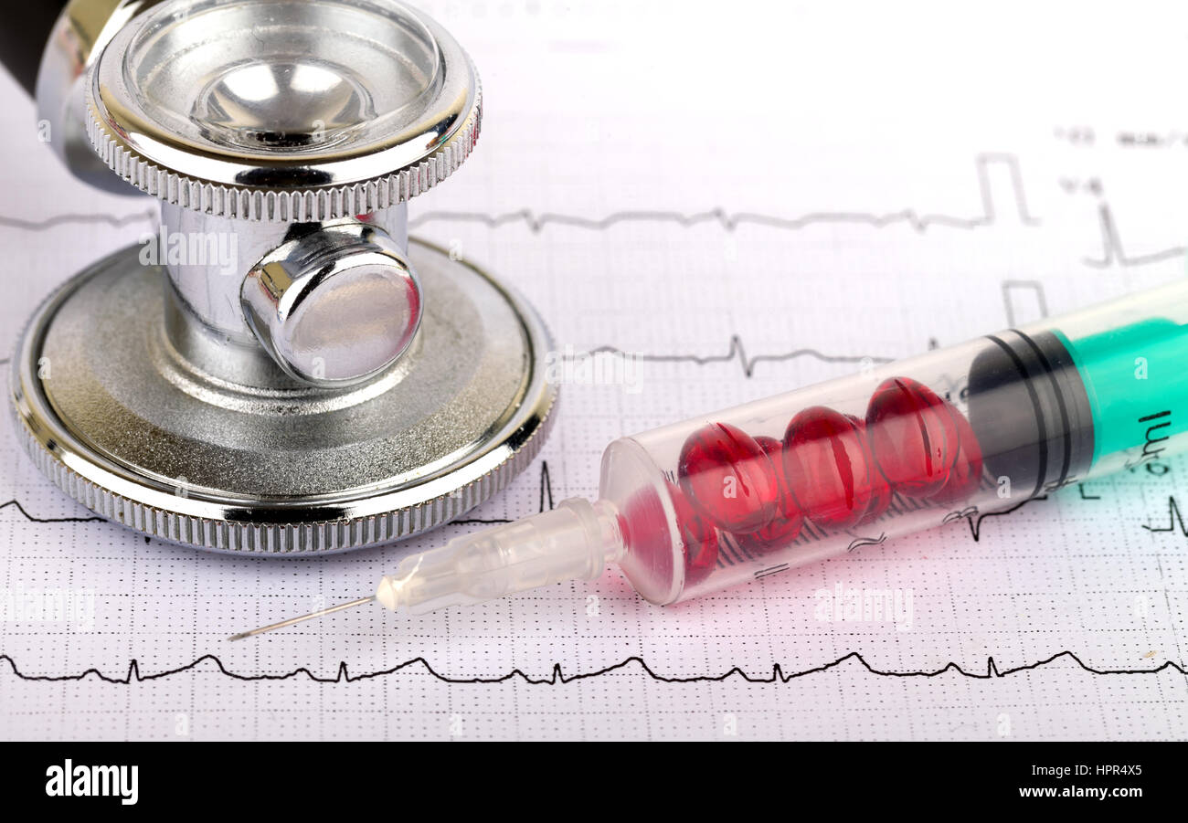 Electrocardiogram graph report with stethoscope and pills on it Stock Photo