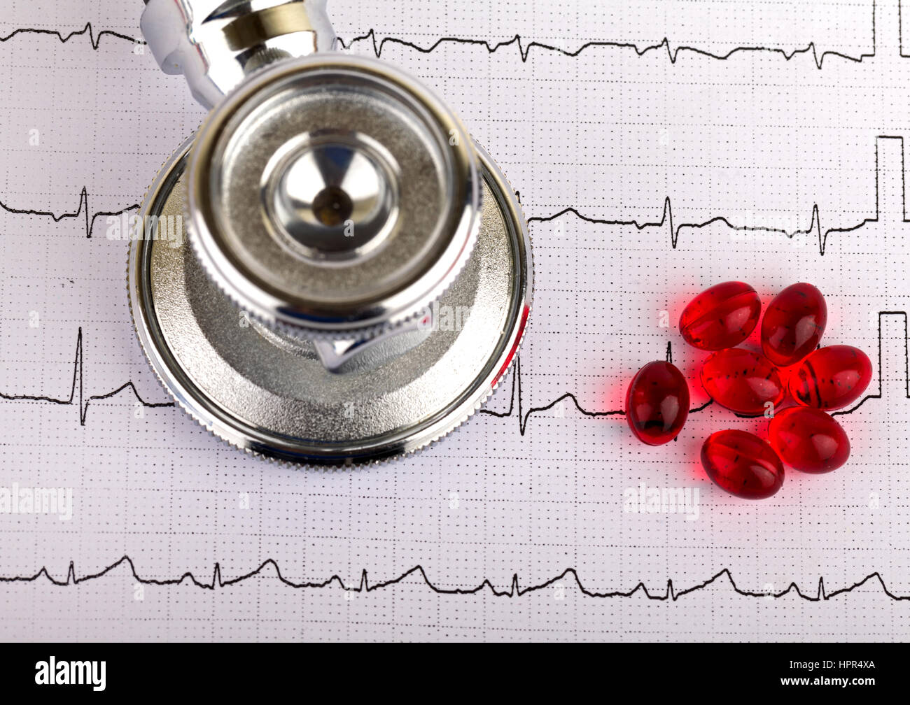 Electrocardiogram graph report with stethoscope and pills on it Stock Photo