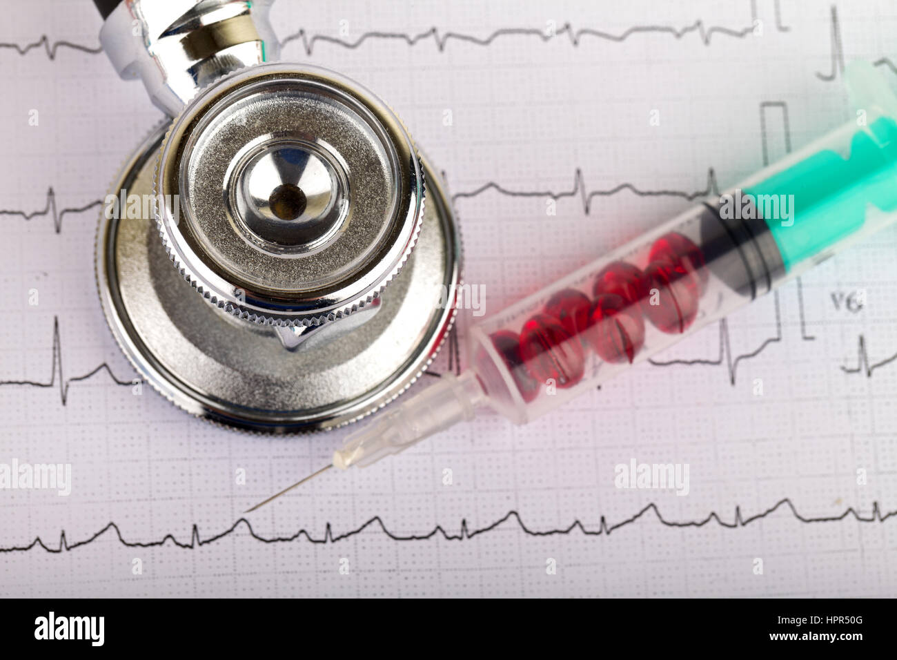 Electrocardiogram graph report with stethoscope and pills on it Stock Photo