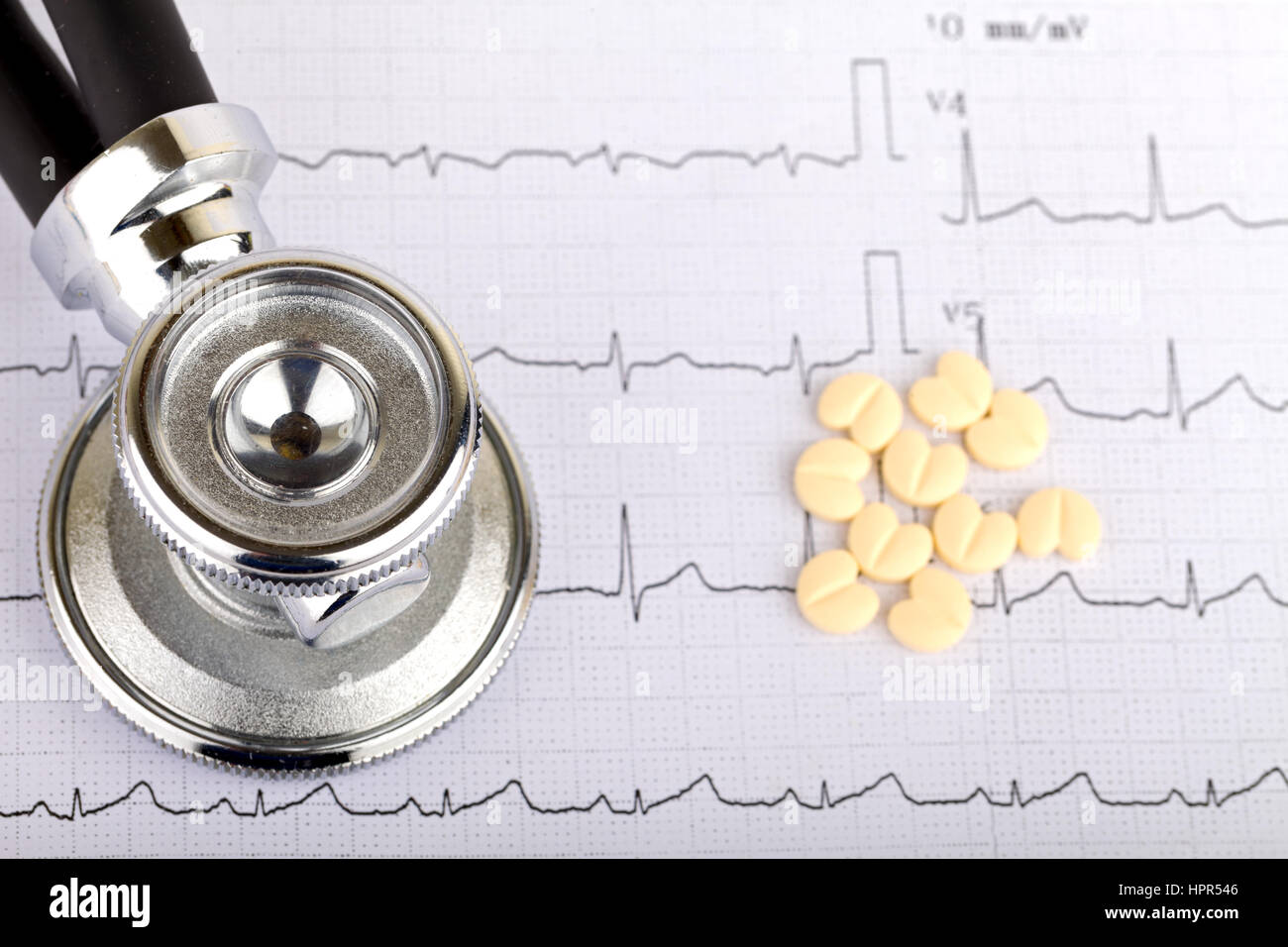 Electrocardiogram graph report with  heart shape pills on it Stock Photo