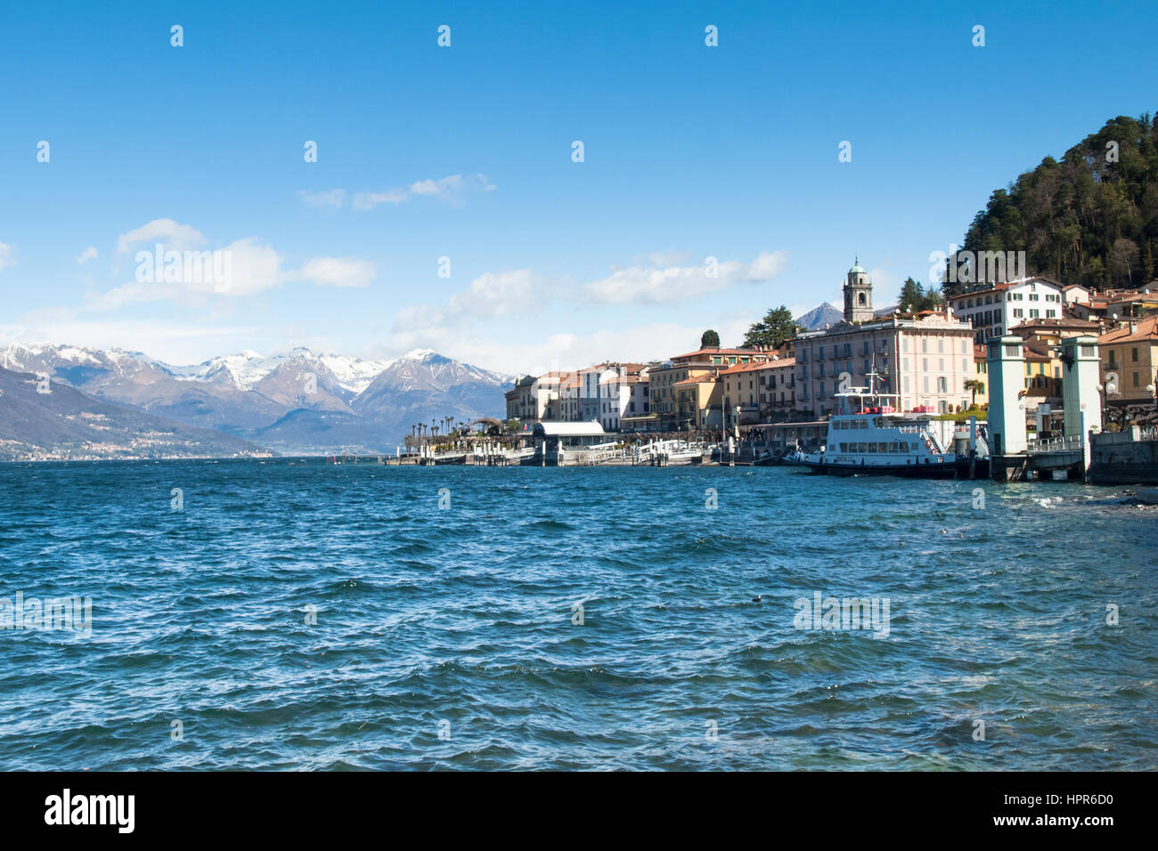 Bellagio lake of Como, Italy - April 1, 2015: Dock of Bellagio with nineteenth-century historic homes. The beautiful day is due to the wind from the n Stock Photo
