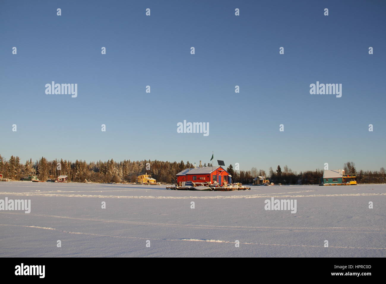 Several houseboats on Yellowknife Bay in Great Slave Lake with a red