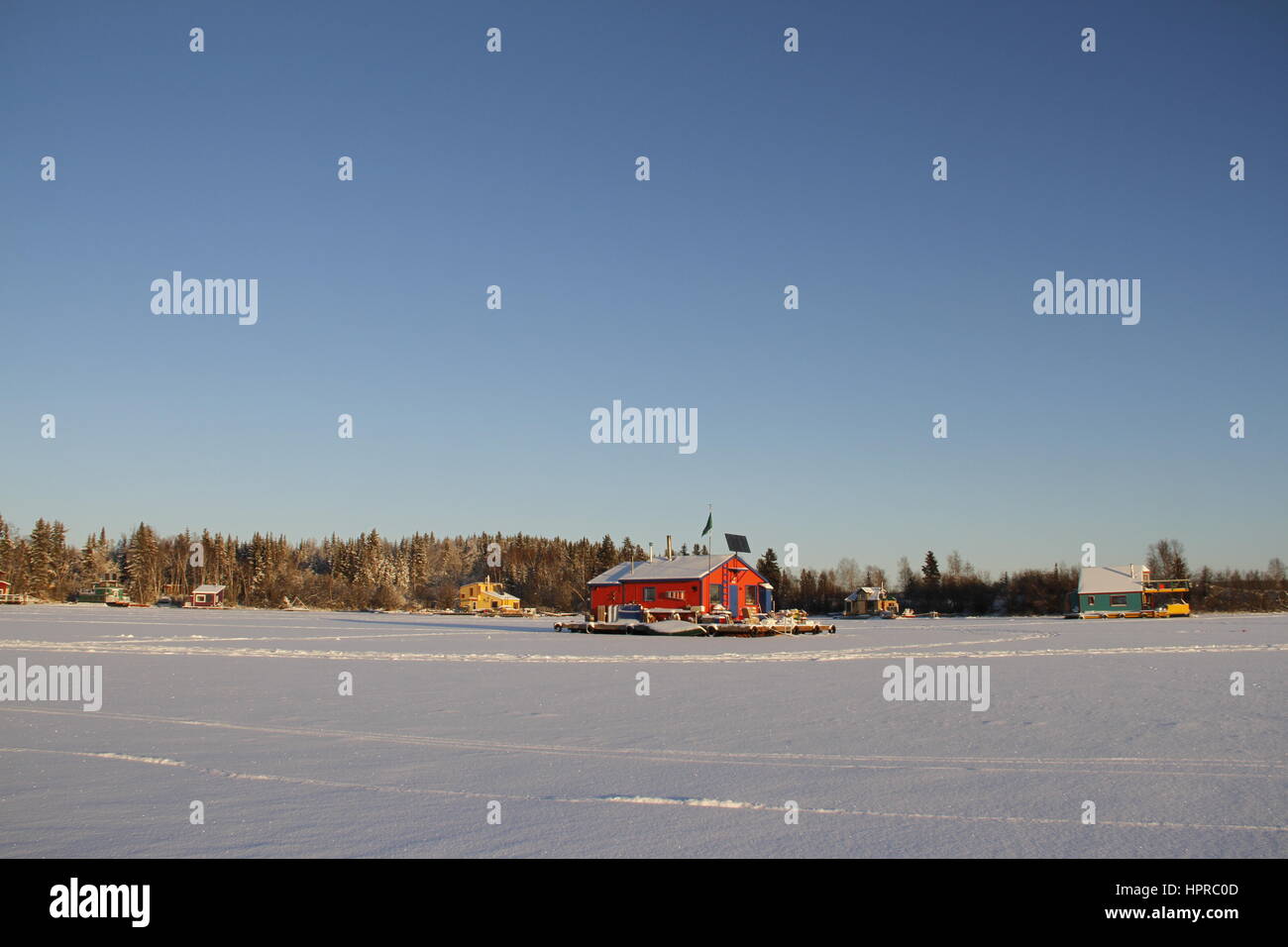 Several houseboats on Yellowknife Bay in Great Slave Lake with a red houseboat in the middle of the frame Stock Photo