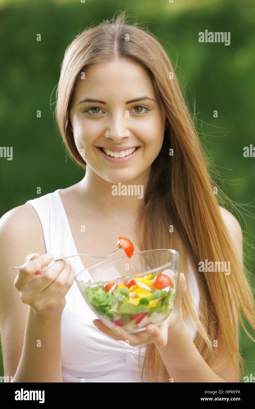 Portrait of young happy woman eating salad Stock Photo Alamy