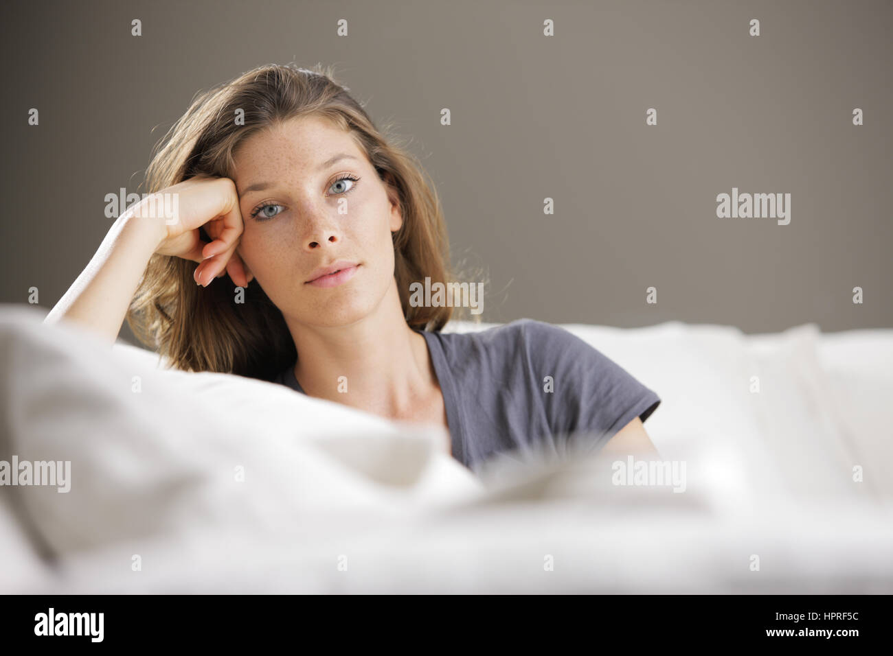 Portrait of beautiful young woman relaxing on couch Stock Photo - Alamy