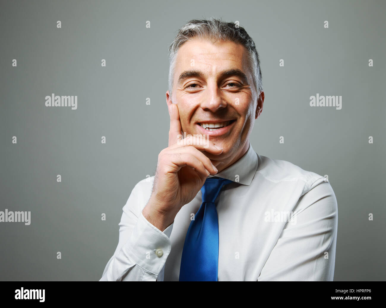 Portrait of a handsome mature man smiling on grey background Stock ...
