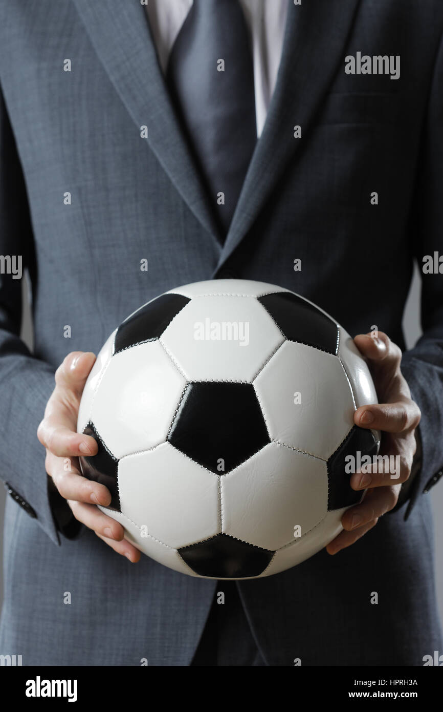 Elegant businessman holding a soccer ball, close up Stock Photo - Alamy