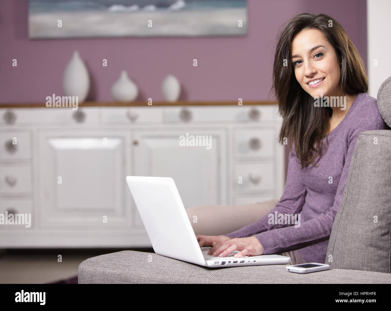 portrait of young woman on the sofa using laptop Stock Photo - Alamy