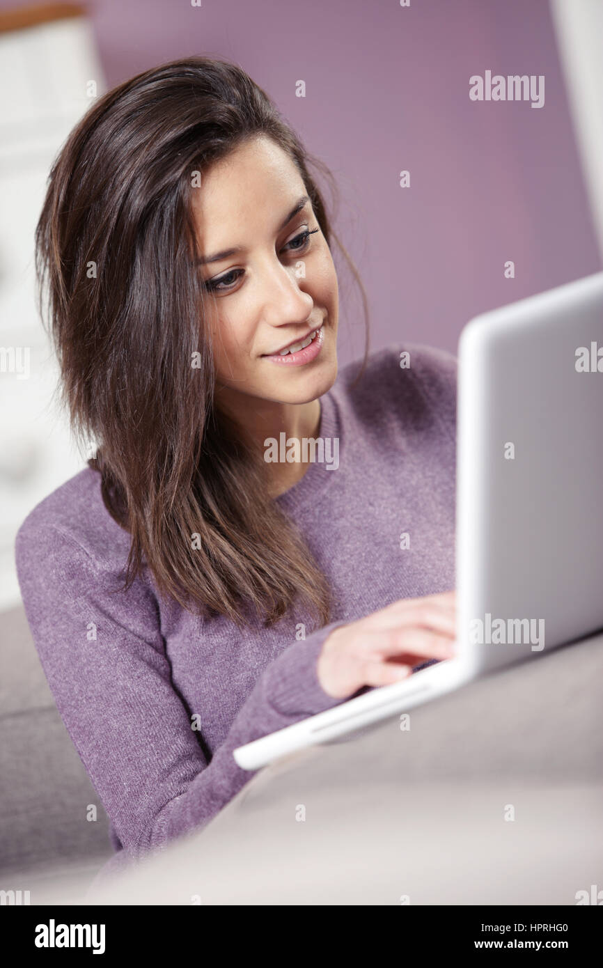 portrait of young woman on the sofa using laptop Stock Photo - Alamy