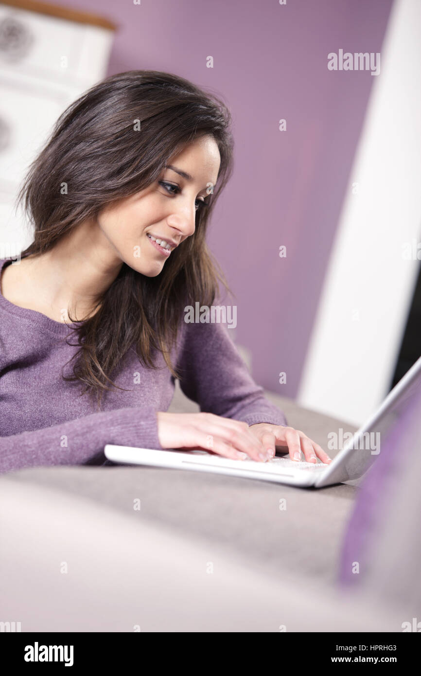 portrait of young woman on the sofa using laptop Stock Photo - Alamy