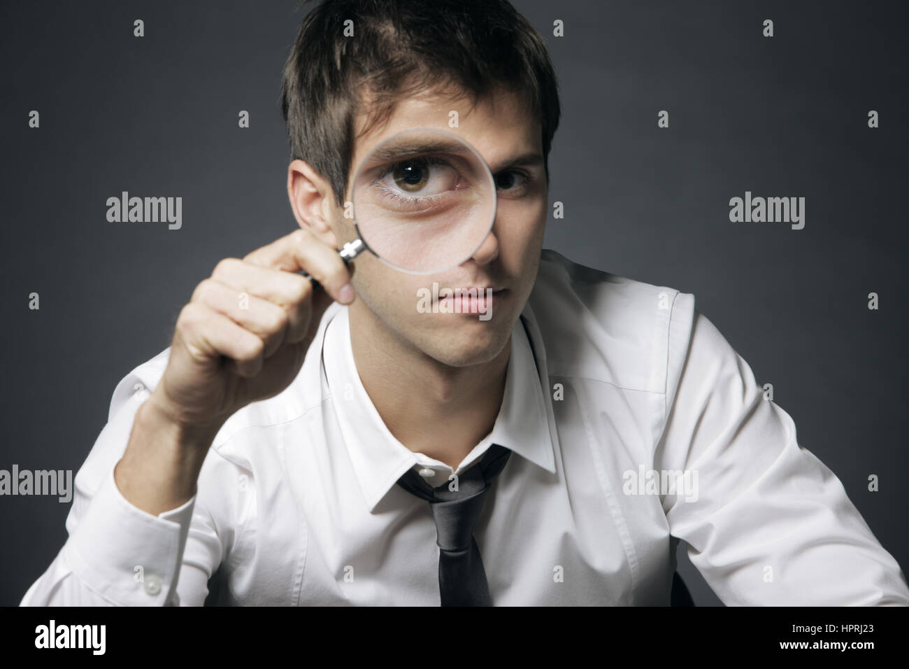businessman looking through a magnifying glass Stock Photo - Alamy