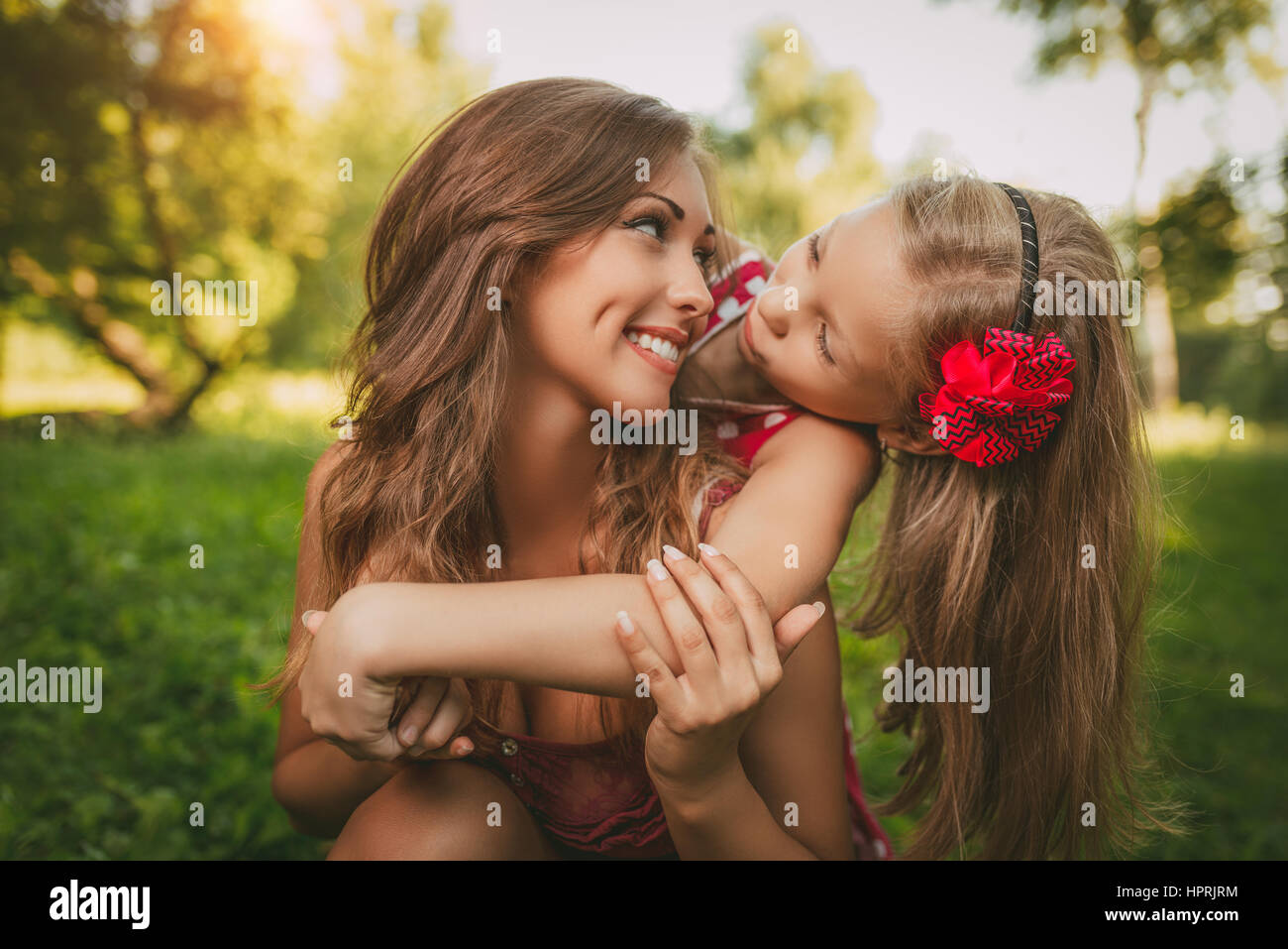 Beautiful mother and daughter having fun at the park in spring day. Stock Photo