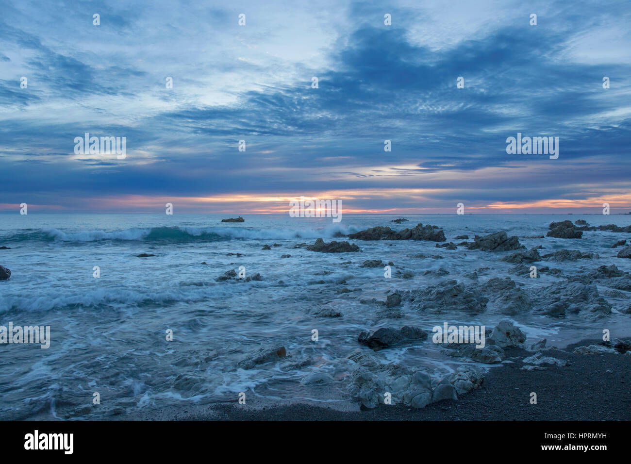 Kaikoura, Canterbury, New Zealand. View across the Pacific Ocean from rocky shoreline at sunrise. Stock Photo