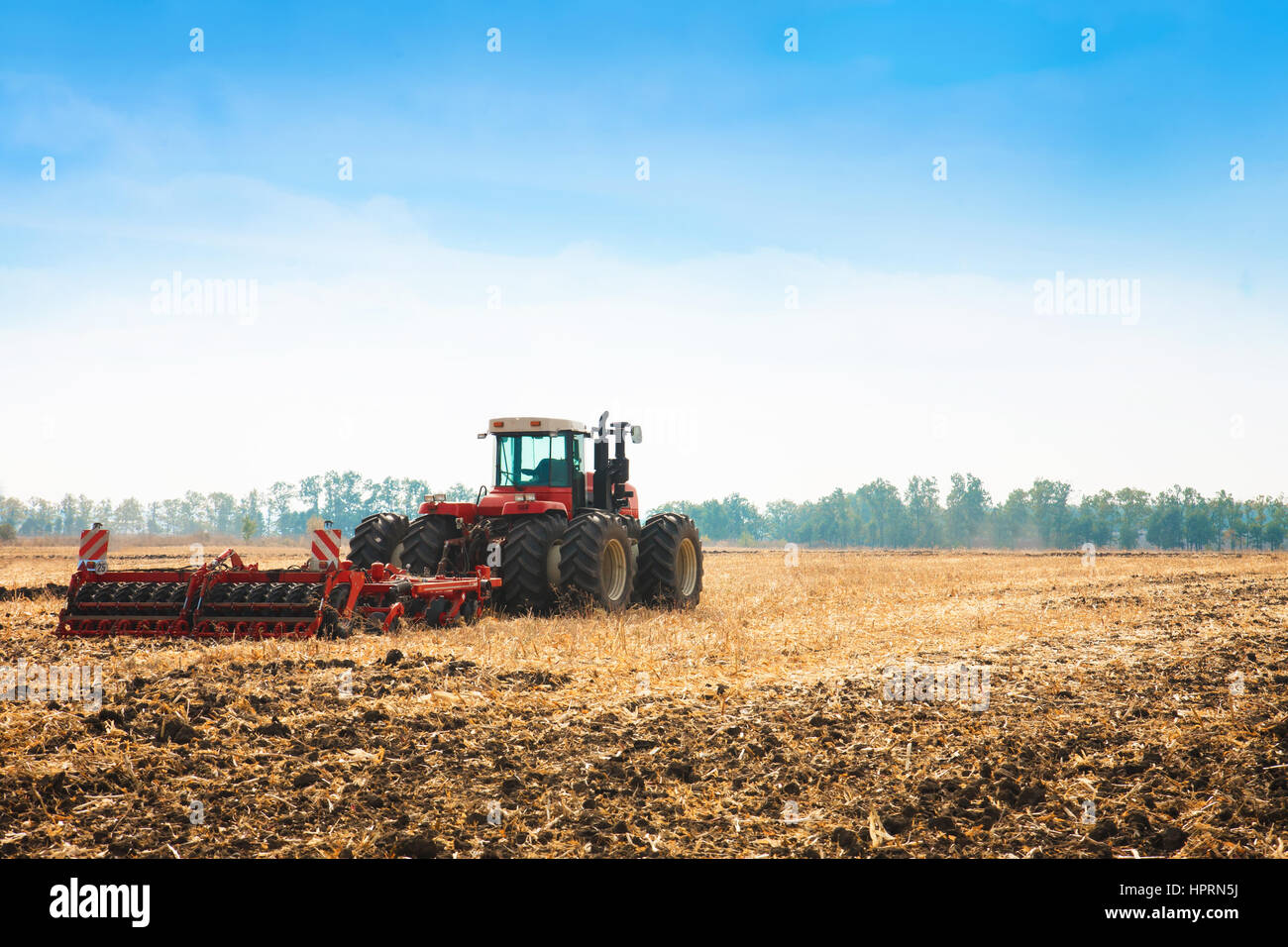 Modern tractor in the field with complex for the plowing of soil. The ...