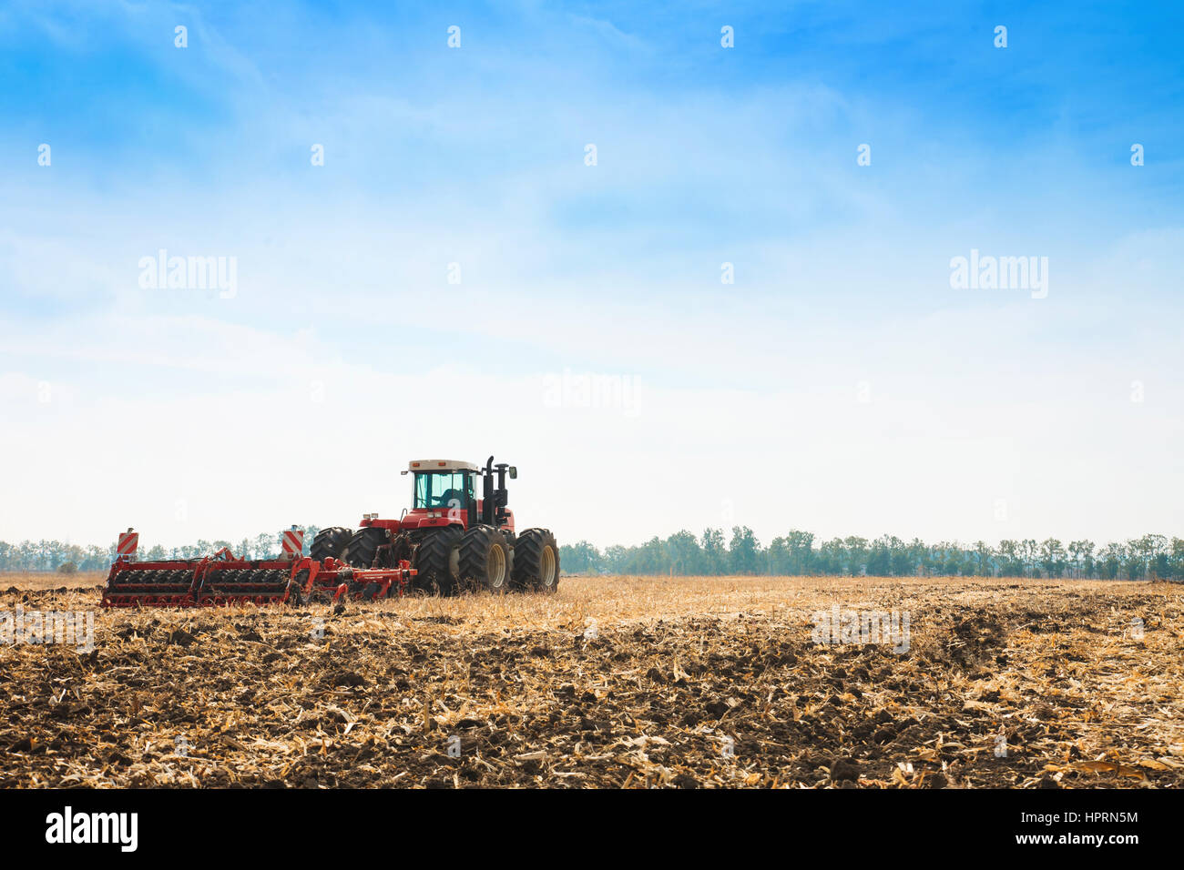 Modern tractor in the field with complex for the plowing of soil. The ...